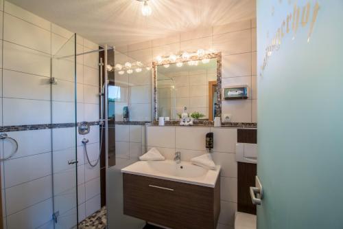 a bathroom with a sink and a shower and a mirror at Haflingerhof in Kramsach