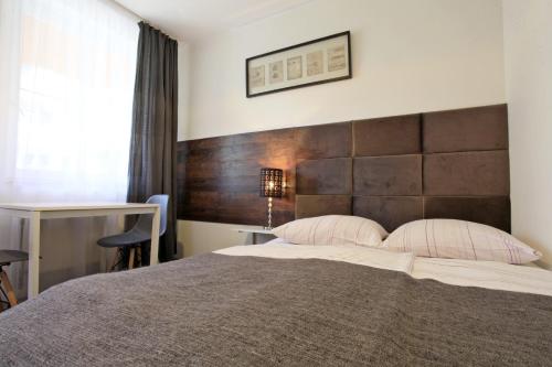 a bedroom with a large bed with a wooden headboard at Willa Park Międzyzdroje in Międzyzdroje