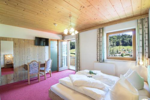 una camera con letto, tavolo e sedie di Haflingerhof a Kramsach