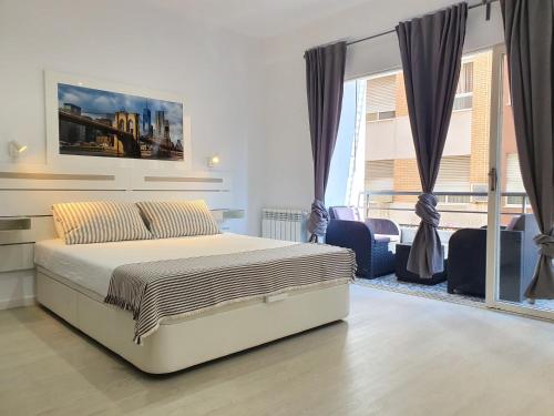 a bedroom with a bed and a large window at CasaMila Guest House in Alicante