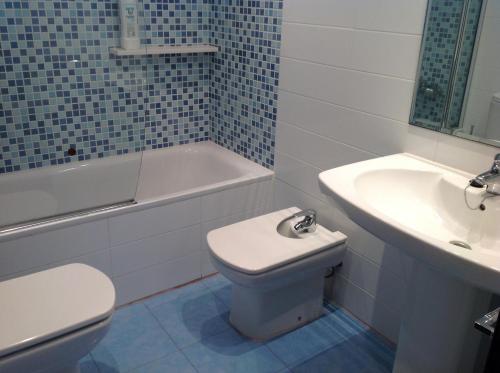 a bathroom with a white toilet and a sink at Urbanizacion primera línea de playa in Denia