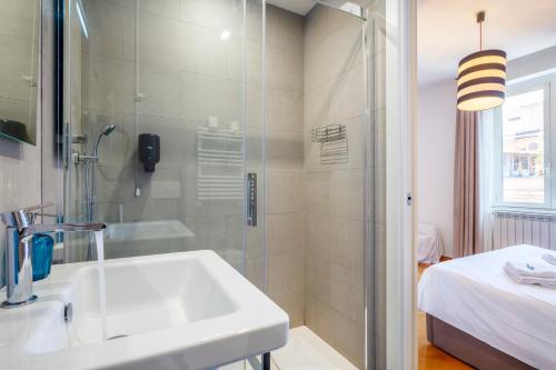 a bathroom with a sink and a glass shower at HT Residence Maximus in Rome