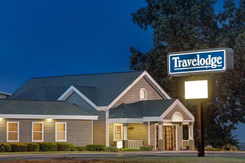 a house with a truck catalogue sign in front of it at Travelodge by Wyndham Iowa City in Iowa City