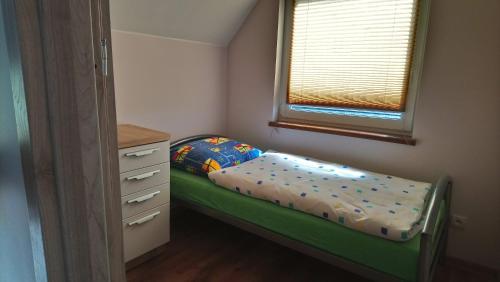 a small bedroom with a bed and a dresser at Apartamenty u Beaty in Rewal