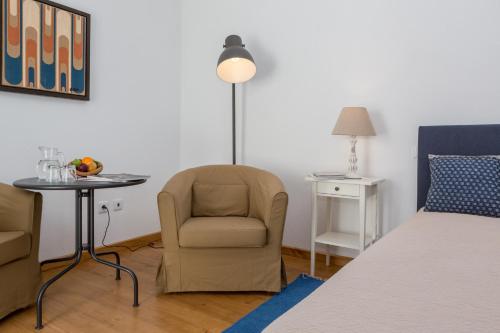 a room with a bed and a chair and a table at Monte das Texugueiras in Texugueira