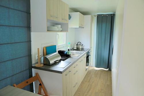 a kitchen with a sink and a printer on a counter at Pensjonat Rybaczówka in Giżycko