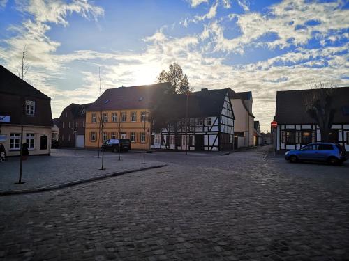 une rue pavée dans une ville avec des bâtiments dans l'établissement Strada Giardino Tangermünde, à Tangermünde