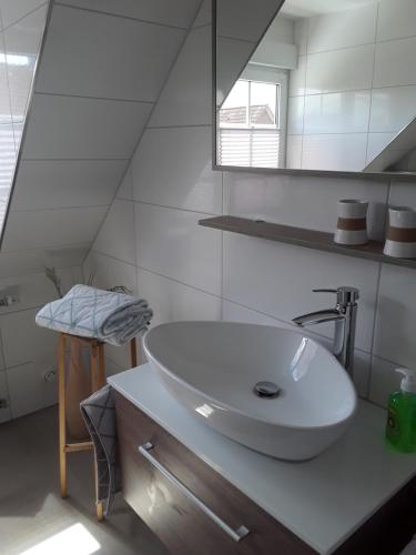 a white bathroom with a sink and a mirror at Korth Pilsum in Manslagt