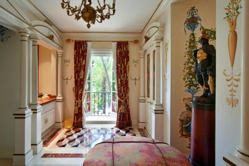 a bedroom with a bed and a window and a chandelier at The Villa Casa Casuarina in Miami Beach