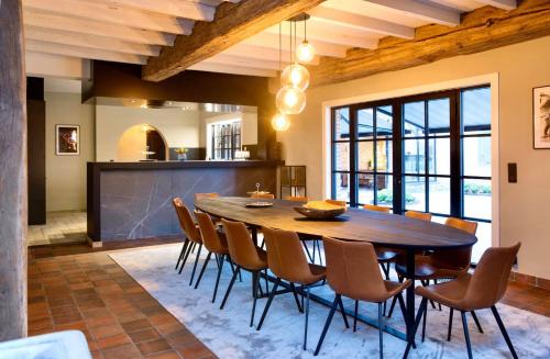 a dining room with a wooden table and chairs at 't Averhuys in Itegem
