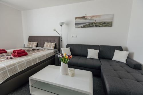 een woonkamer met een bed en een bank bij Apartmán 15 MyMara in Bešeňová