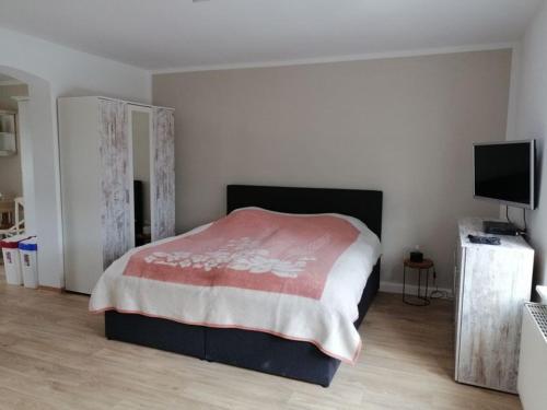 a bedroom with a bed with a red and white blanket at Ferienwohnung im Spreewald "Vivien" in Vetschau