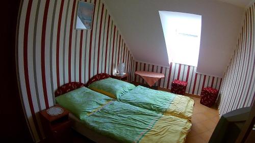 a bedroom with a bed with a striped wall at Abigél Vendégház in Harkány