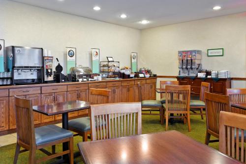 a restaurant with wooden tables and chairs and a counter at Country Inn & Suites by Radisson, Peoria North, IL in Peoria