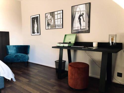 a room with a desk with a laptop and a chair at 't Averhuys in Itegem