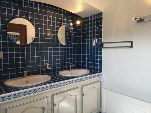 La salle de bains en carrelage bleu est pourvue de 2 lavabos et de 2 miroirs. dans l'établissement Villa ANTINEA, A SAINT AYGULF, PISCINE PRIVEE, VUE MER PANORAMIQUE, à Fréjus