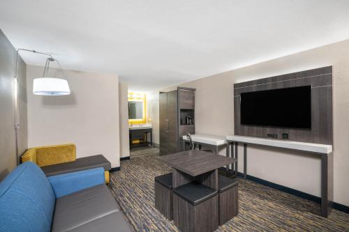 a living room with a couch and a flat screen tv at Baymont by Wyndham Murfreesboro in Murfreesboro