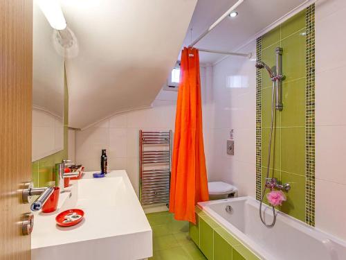 a bathroom with an orange shower curtain and a sink at Dilira Villas in Agia Pelagia