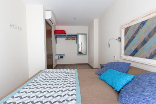 1 dormitorio con 1 cama y 2 almohadas azules en Apartamentos El Gallo, en Marbella
