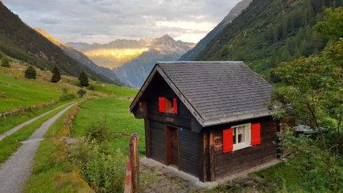 a small house with red doors on a mountain at Gästehaus Alpenglühn in Meien