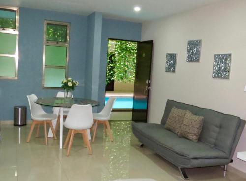 a living room with a couch and a table and chairs at Palmarena Rooms & Residences - Long Stay Comfort with Parking, Sauna, Gym & Pool - Steps from 5th Avenue in Playa del Carmen
