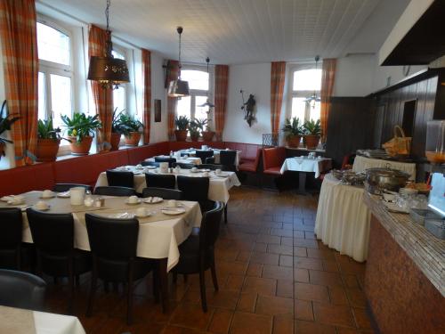 Jakoberhof في اوغسبورغ: غرفة طعام مع طاولات وكراسي في مطعم