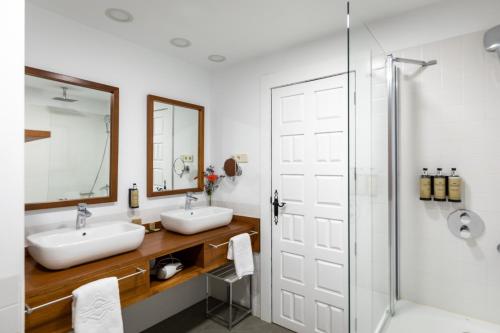 a bathroom with two sinks and a shower at Parador de La Gomera in San Sebastián de la Gomera