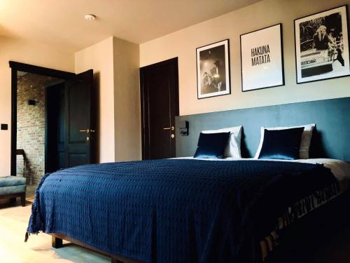 a bedroom with a blue bed with two pillows at 't Averhuys in Itegem