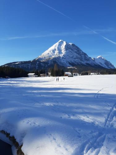 a snow covered mountain in front of a snow covered field at Haus Sonnenweg in Leutasch