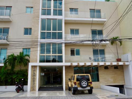 a jeep parked in front of a building at Palmarena Rooms & Residences - Long Stay Comfort with Parking, Sauna, Gym & Pool - Steps from 5th Avenue in Playa del Carmen