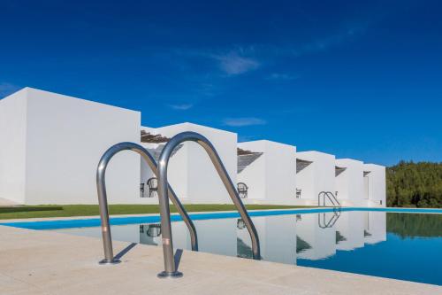 a view of a swimming pool with white buildings at Monte das Texugueiras in Texugueira