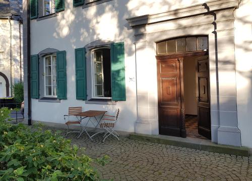 un edificio con una mesa y sillas frente a una puerta en Ehem. Sommerresidenz von Fürst Friedrich III. App.1 und App.2, en Kirn