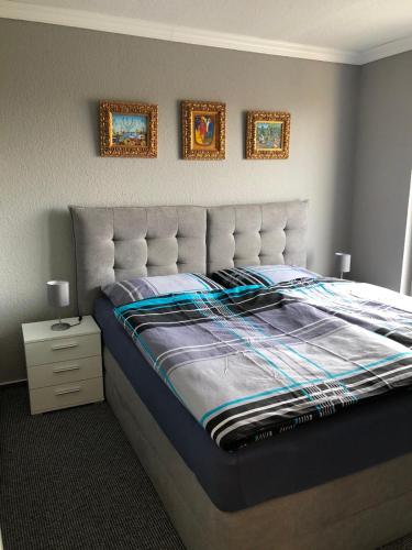 ein Bett in einem Schlafzimmer mit zwei Bildern an der Wand in der Unterkunft Ferienwohnung Schwede in Surendorf