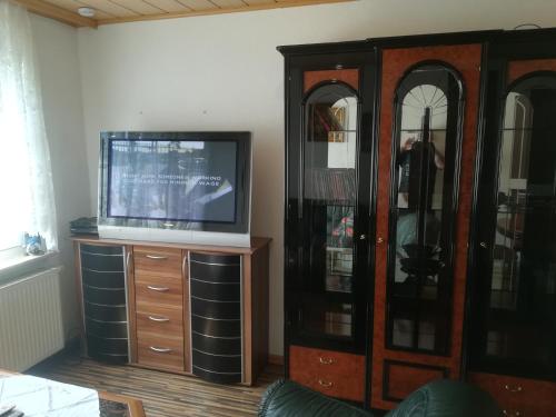 a living room with a tv and a entertainment center at Ländliche Erholung 1 in Heideland