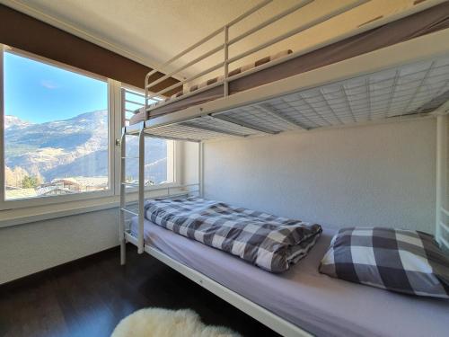 a bedroom with a bunk bed and a large window at Atlantic 1 in Saas-Fee
