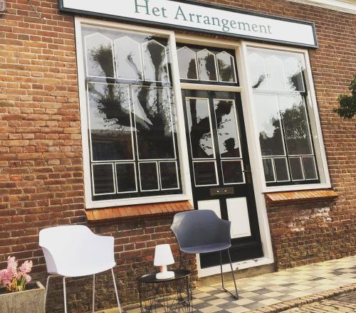 a set of chairs sitting outside of a left entrance at Het arrangement in Wemeldinge