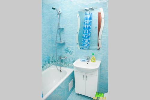 bagno blu con lavandino, vasca e servizi igienici di Героев Днепра 53, рядом пляж a Čerkasy