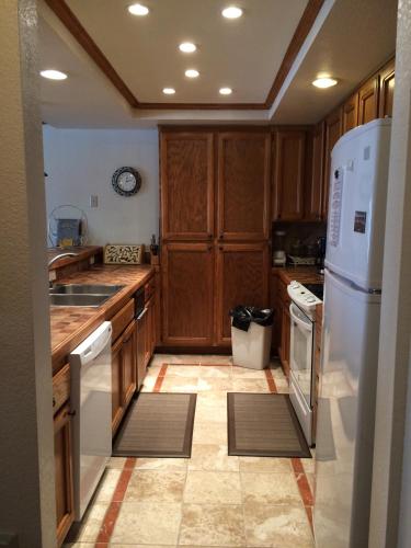 a kitchen with wooden cabinets and a white refrigerator at Mountainback #71 in Mammoth Lakes