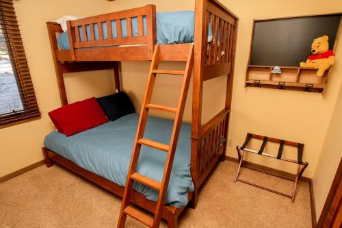 a bedroom with two bunk beds and a television at Mountainback #73, Den in Mammoth Lakes