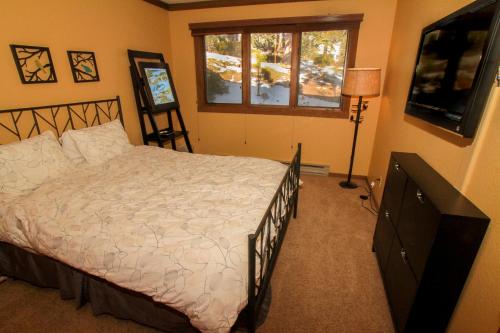 a bedroom with a bed and a window and a television at Mountainback #73, Den in Mammoth Lakes