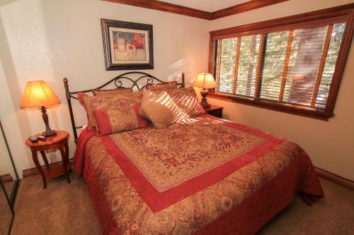 a bedroom with a bed and two lamps and a window at Mammoth Ski & Racquet Club #34 in Mammoth Lakes