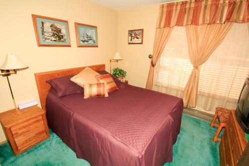1 dormitorio con cama morada y ventana en Discovery 4 #137, en Mammoth Lakes