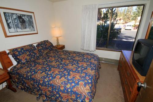 a bedroom with a bed and a flat screen tv at Discovery 4 #135 in Mammoth Lakes