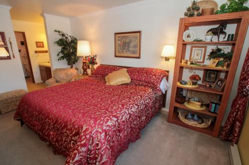 1 dormitorio con 1 cama con colcha roja en Mountainback #38 en Mammoth Lakes