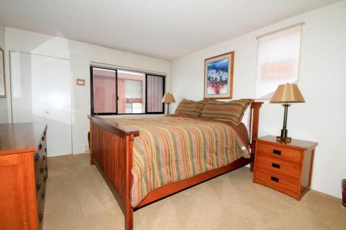 a bedroom with a bed and a dresser and a window at Mammoth Ski & Racquet Club #62 in Mammoth Lakes