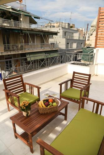 two chairs and a table with a basket of fruit on a roof at HOTEL_TIER in Athens
