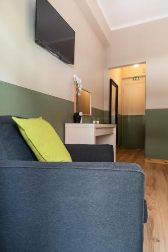 a living room with a couch and a tv on the wall at HOTEL_TIER in Athens