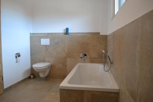 La salle de bains est pourvue d'une baignoire et de toilettes. dans l'établissement Alpenblick Ferienwohnung, à Bad Feilnbach