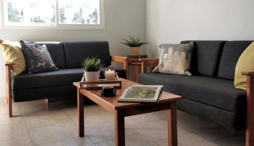a living room with two couches and a coffee table at Anemomylos guesthouse in Paralimni