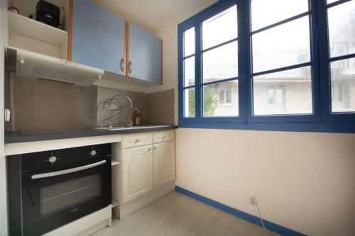eine Küche mit einem schwarzen Backofen und einem Fenster in der Unterkunft Appartement 2 pièces de 48 M2 in Aix-les-Bains